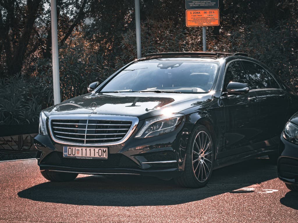 Black Mercedes-Benz luxury saloon, front three-quarter view in daylight